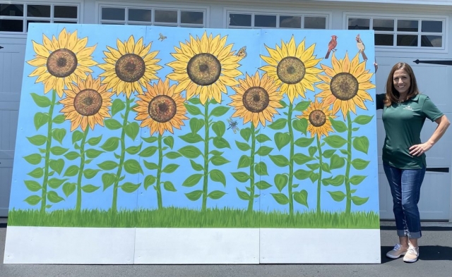 Tremendous thanks to Mary Monteiro for donating her time and talent in creating our beautiful sunflower photo board, which you’ll see in our gallery frequently captured smiles and group shots as people walked through the fields. Mary worked at the Center for many years, helping coordinate our Nello’s Corner and Camp Millie group services, and in the training of our program volunteers. Mary holds a special place in the hearts of countless group participants, staff members, and volunteers who worked alongside her warm, creative, and sensitive spirit.  We are grateful that Mary has remained one of our Center’s passionate advocates and supporters, and we cannot thank her enough for dedicating this meaningful project to our event!